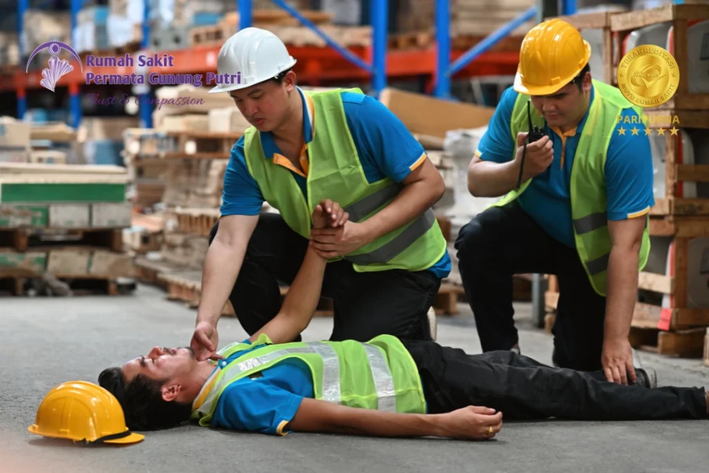 Pertolongan pertama kecelakaan kerja di area industri, menunjukkan penanganan korban tanpa mengangkat tubuh secara sembarangan dalam golden hour